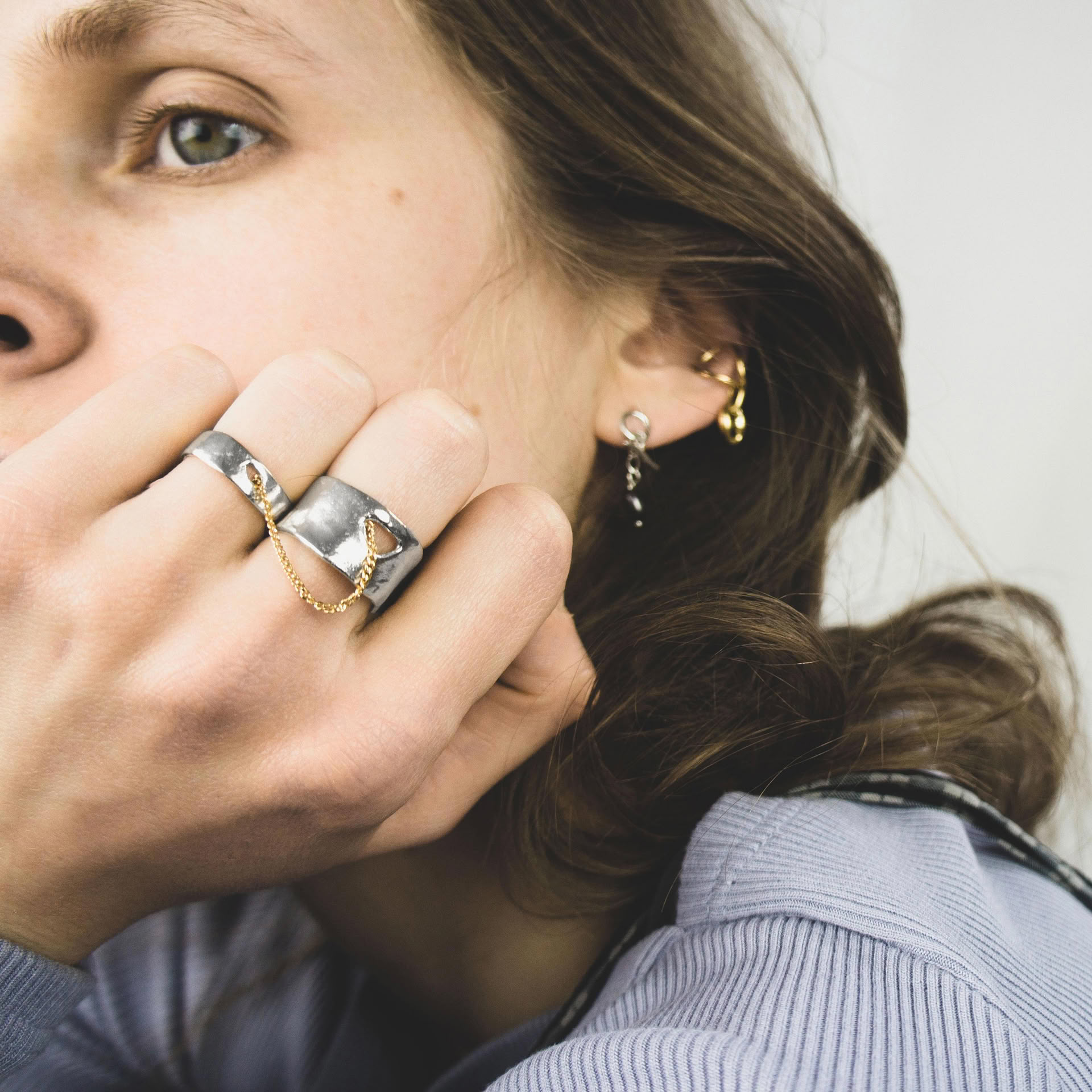 Kara ring composed of two sterling silver bands linked by a 18k gold thin curb chain