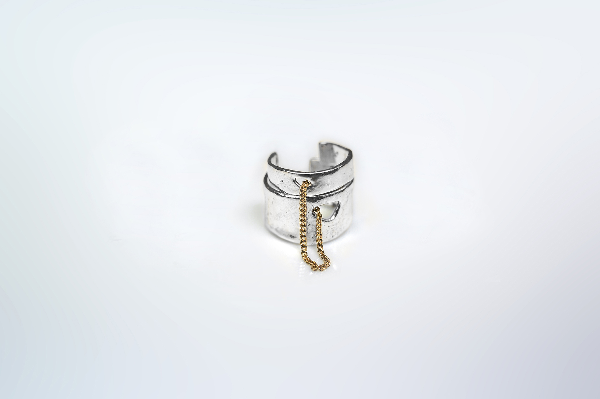 Kara ring composed of two sterling silver bands linked by a 18k gold thin curb chain