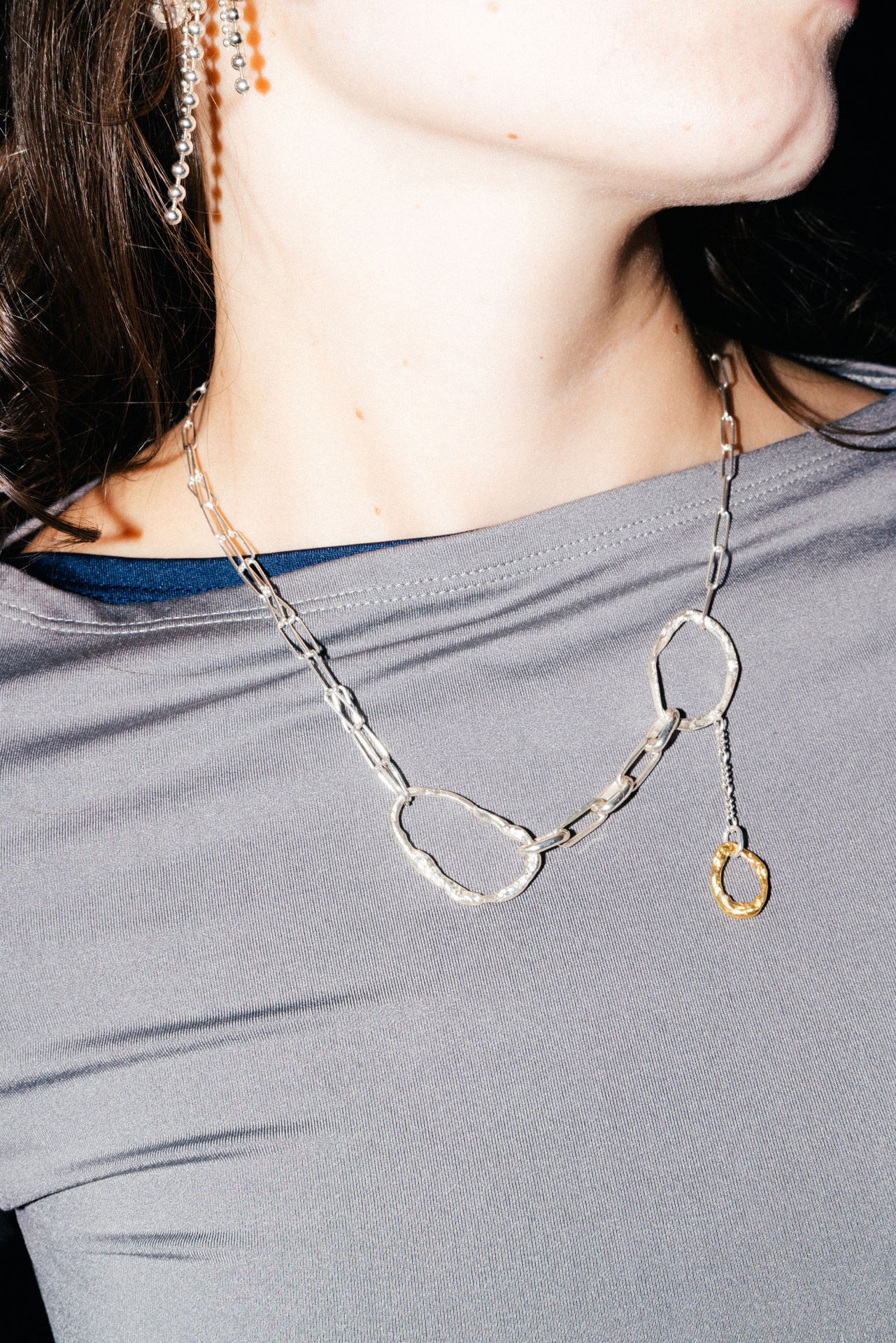 Fuyou sterling silver necklace with fluid elements and gold plated dangling detail.