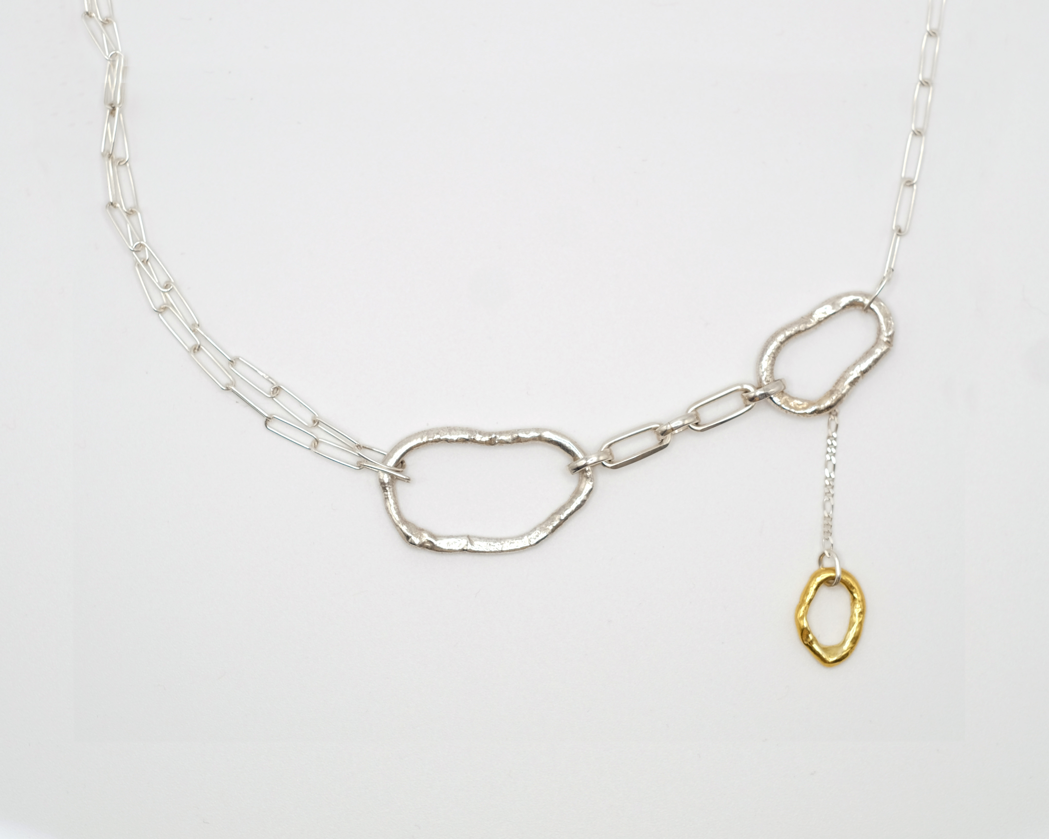 Fuyou sterling silver necklace with fluid elements and gold plated dangling detail.