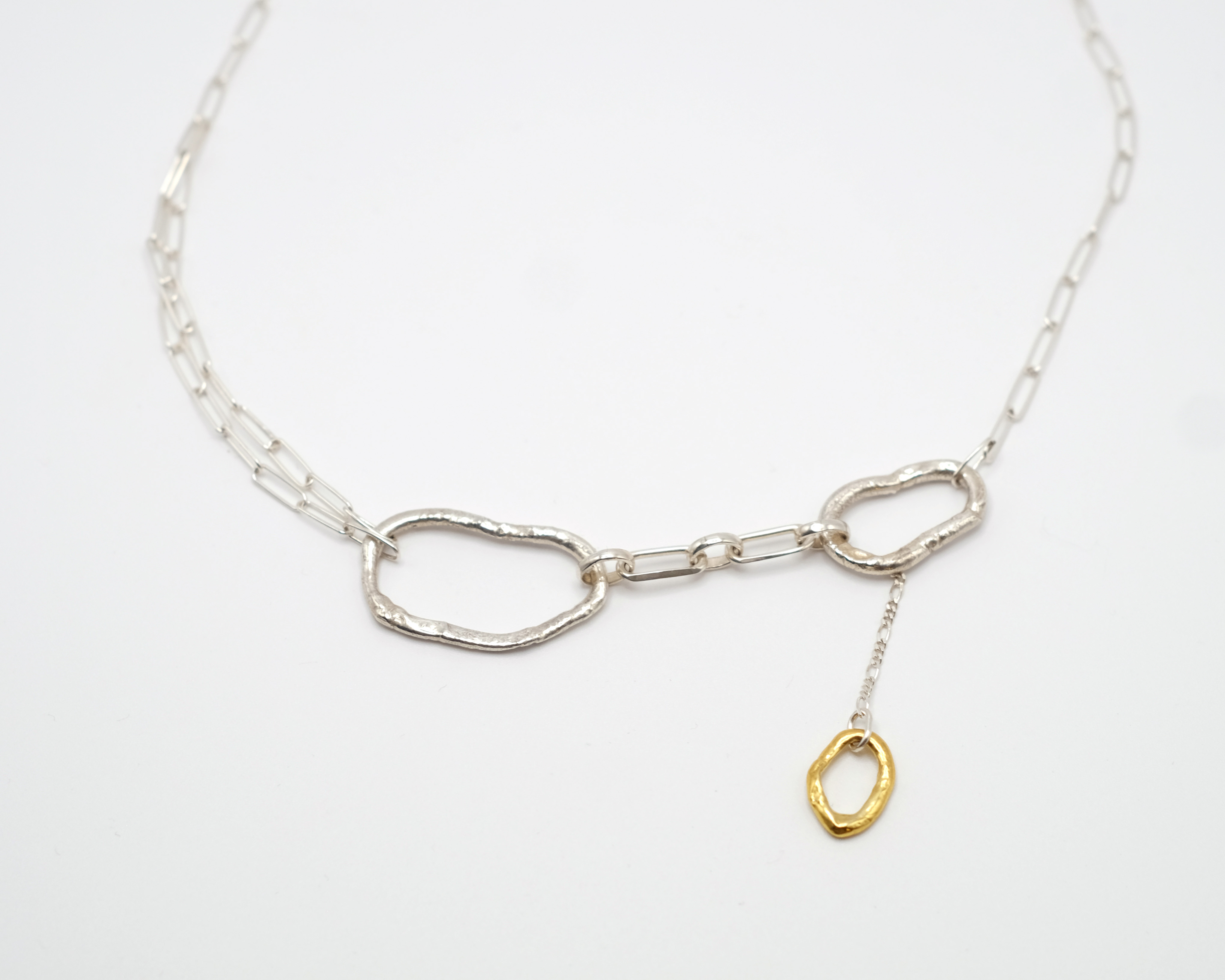 Fuyou sterling silver necklace with fluid elements and gold plated dangling detail.