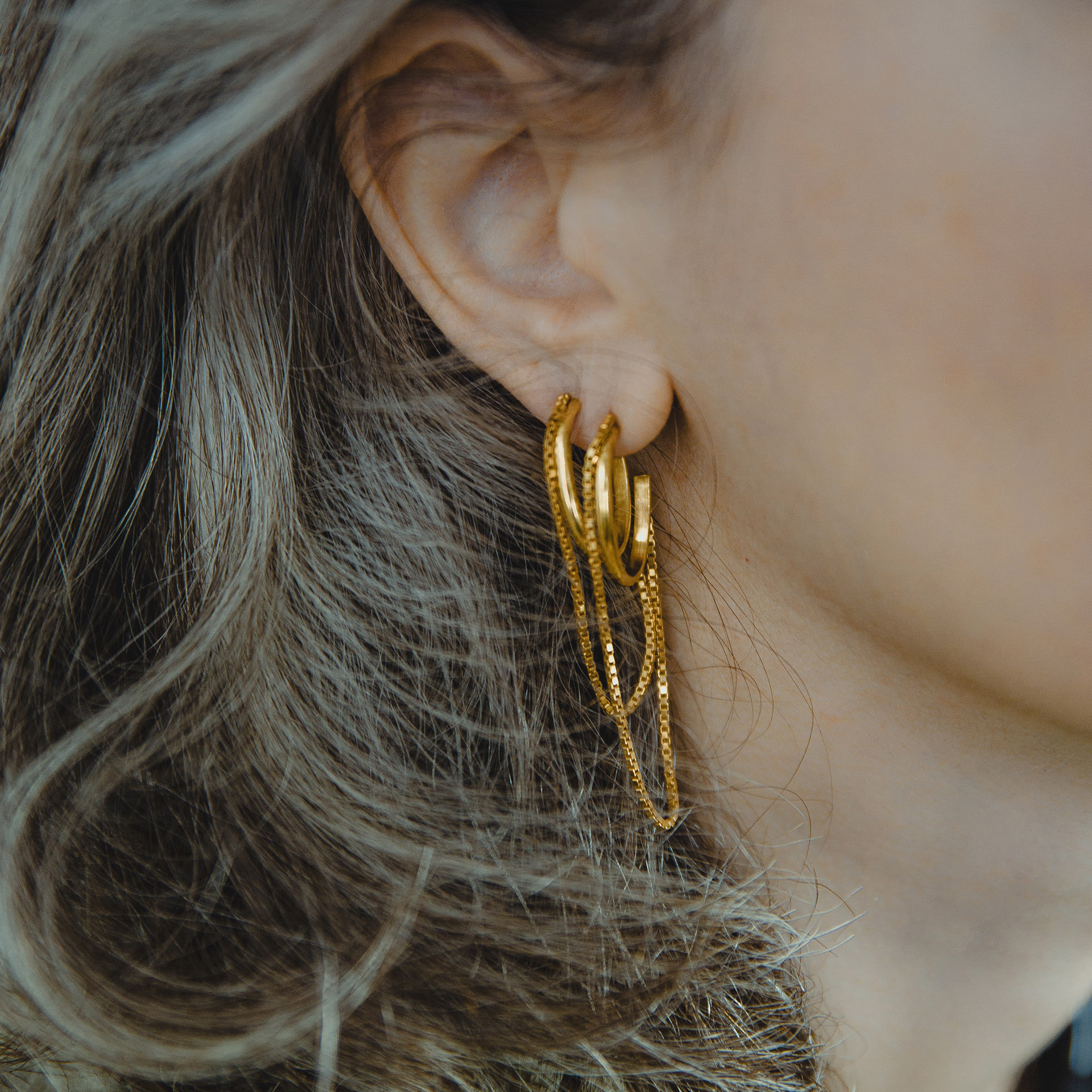 Tamanori oval gold plated hoops with dangling chains.