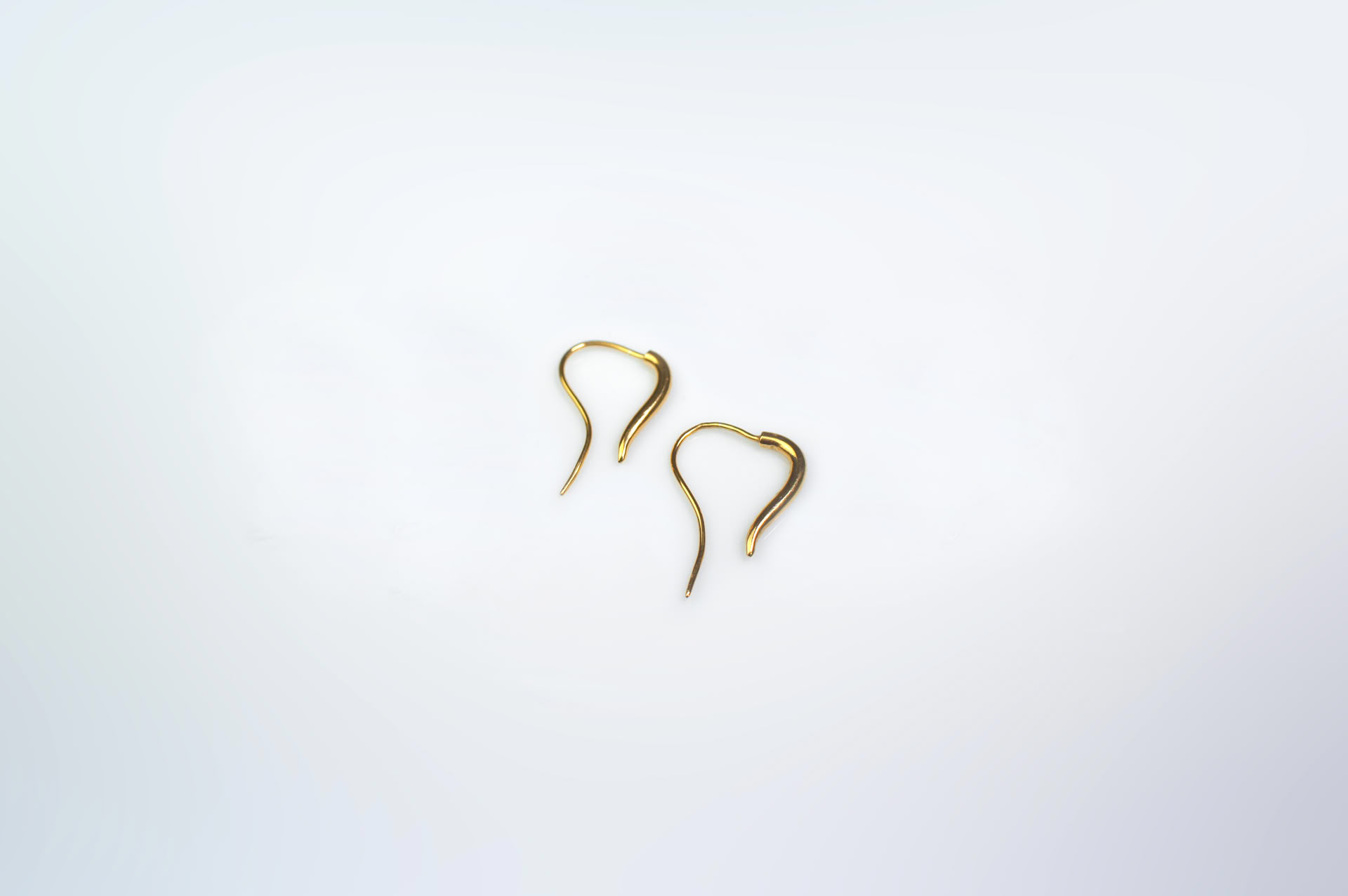 Mugura minimalist opened earrings to slip into the earlobe, in gold plated silver.