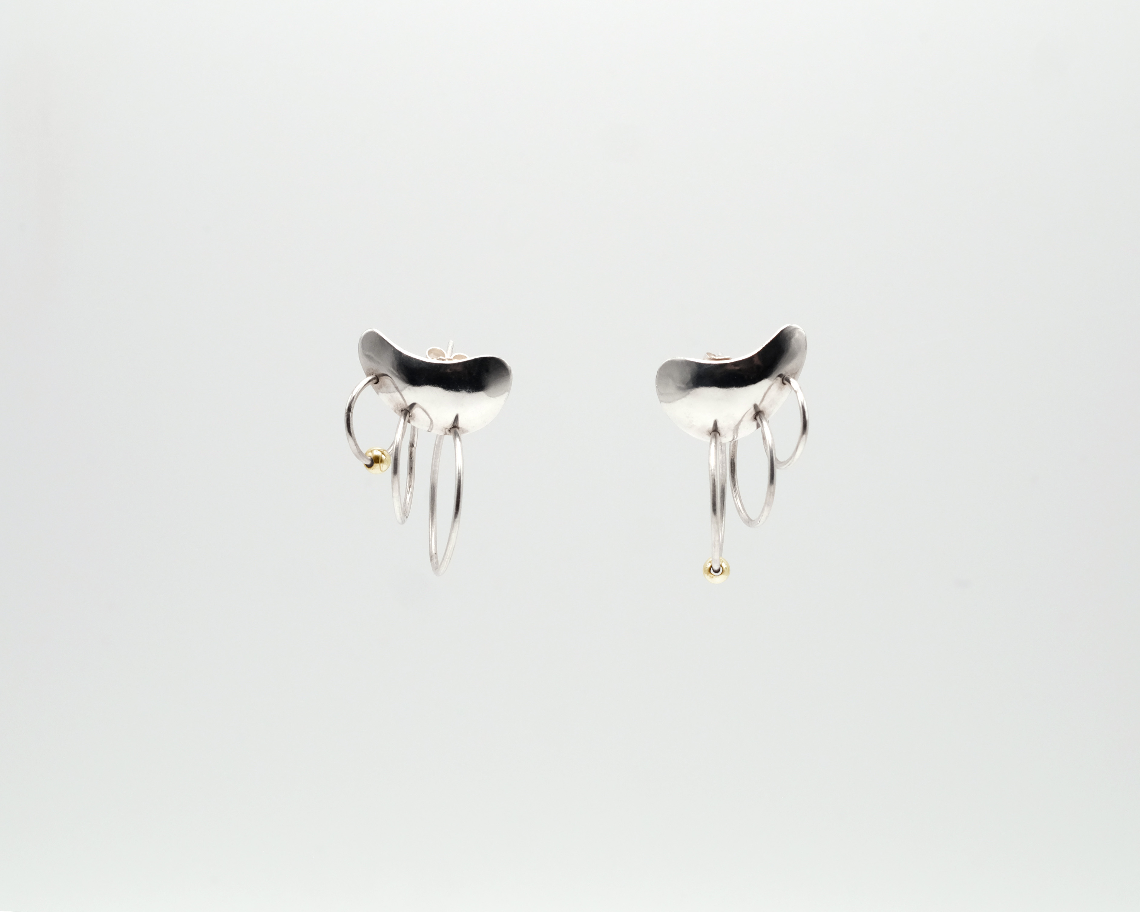 Piasu earrings covering the ear lobe with three hoops hanging on it.