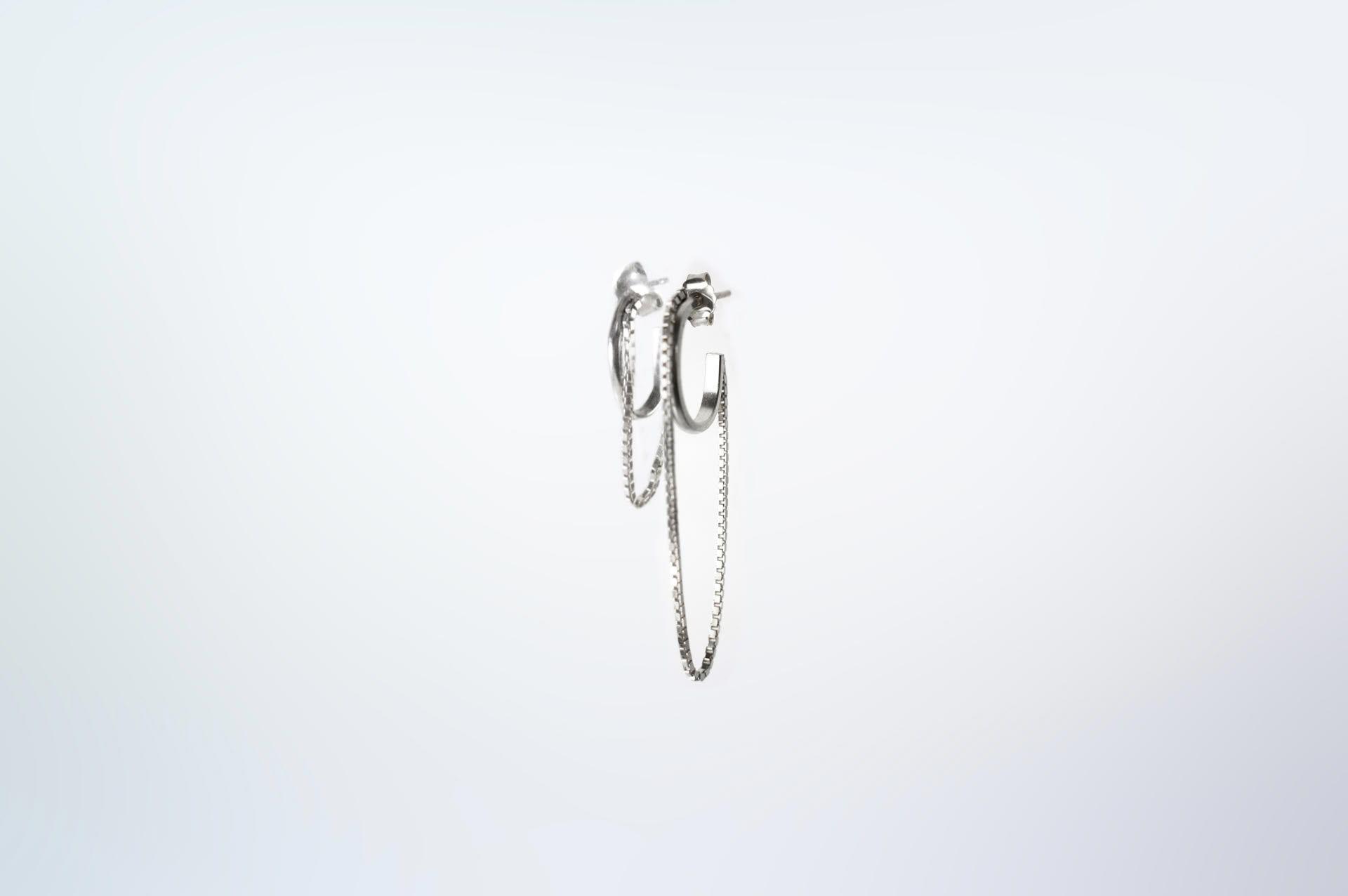 Tamanori oval silver hoops with dangling chains.