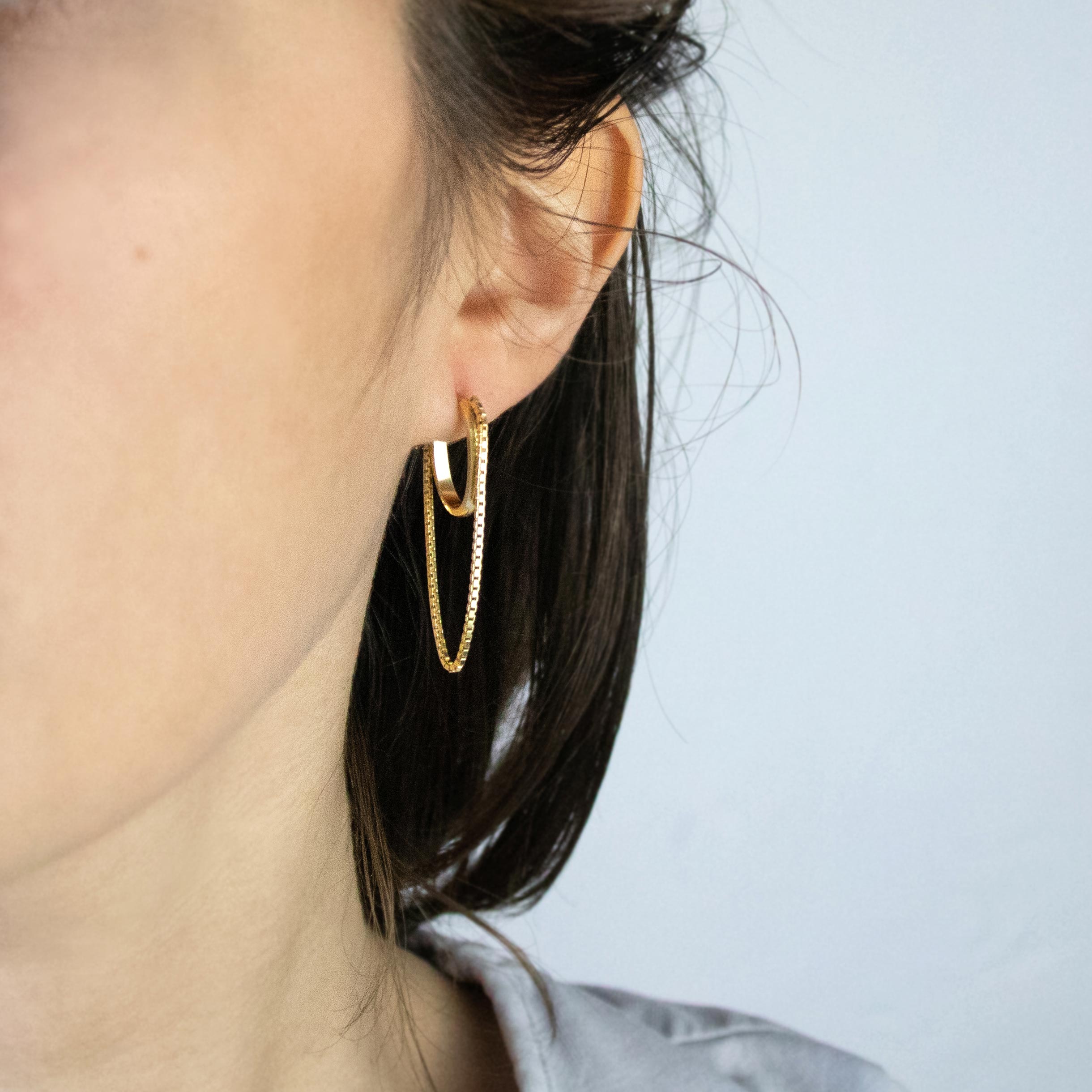 Tamanori oval gold plated hoops with dangling chains.