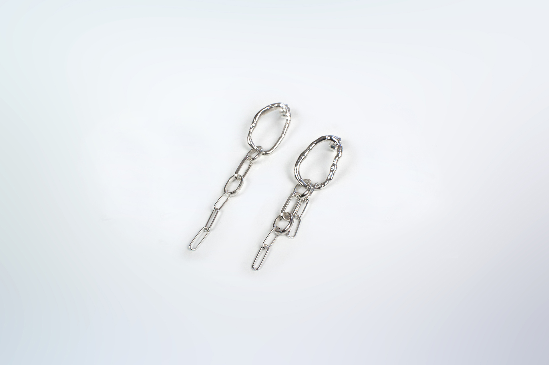 Fuyou long dangling earrings in silver with fluid oval shapes and chains.