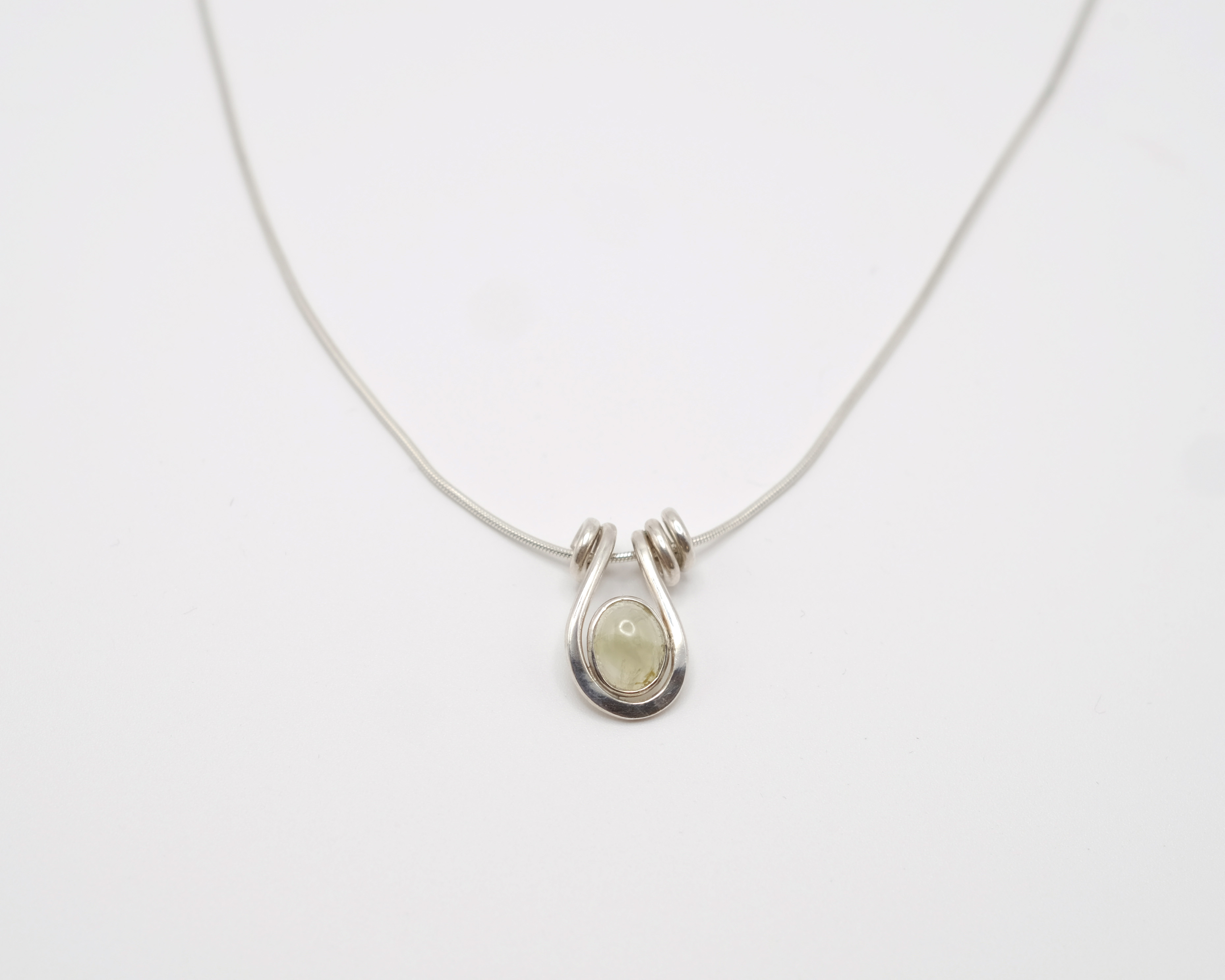 Uteki necklace with a droplet pendant and prehnite oval stone. In gold plated silver.