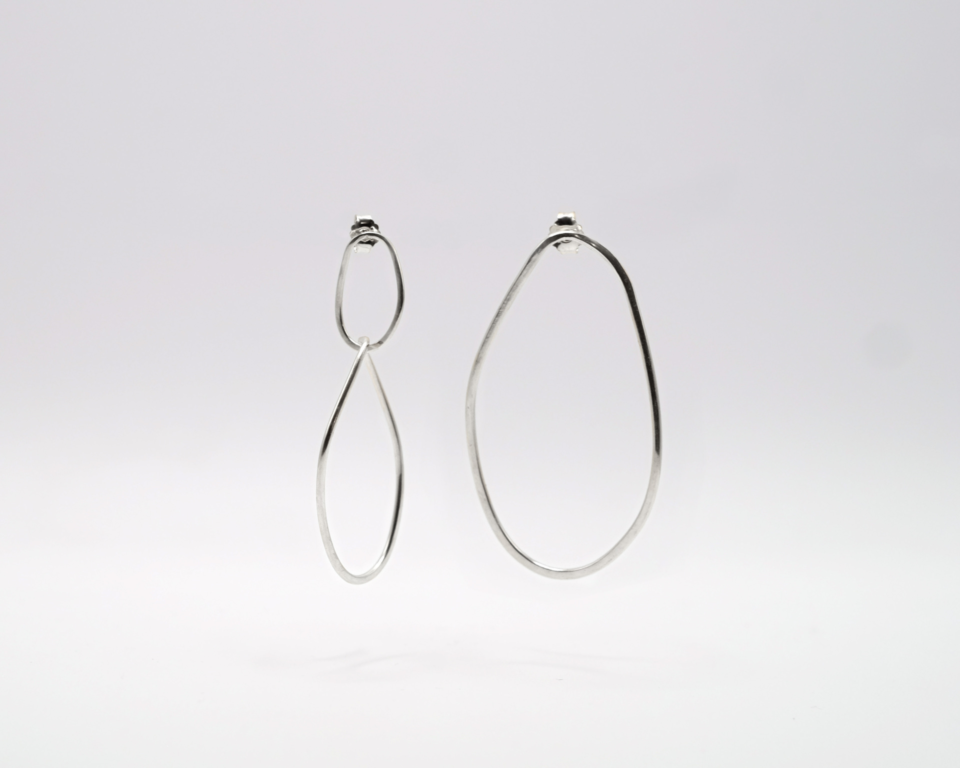 pair of Boroboro long sterling silver earrings with asymmetrical shapes.