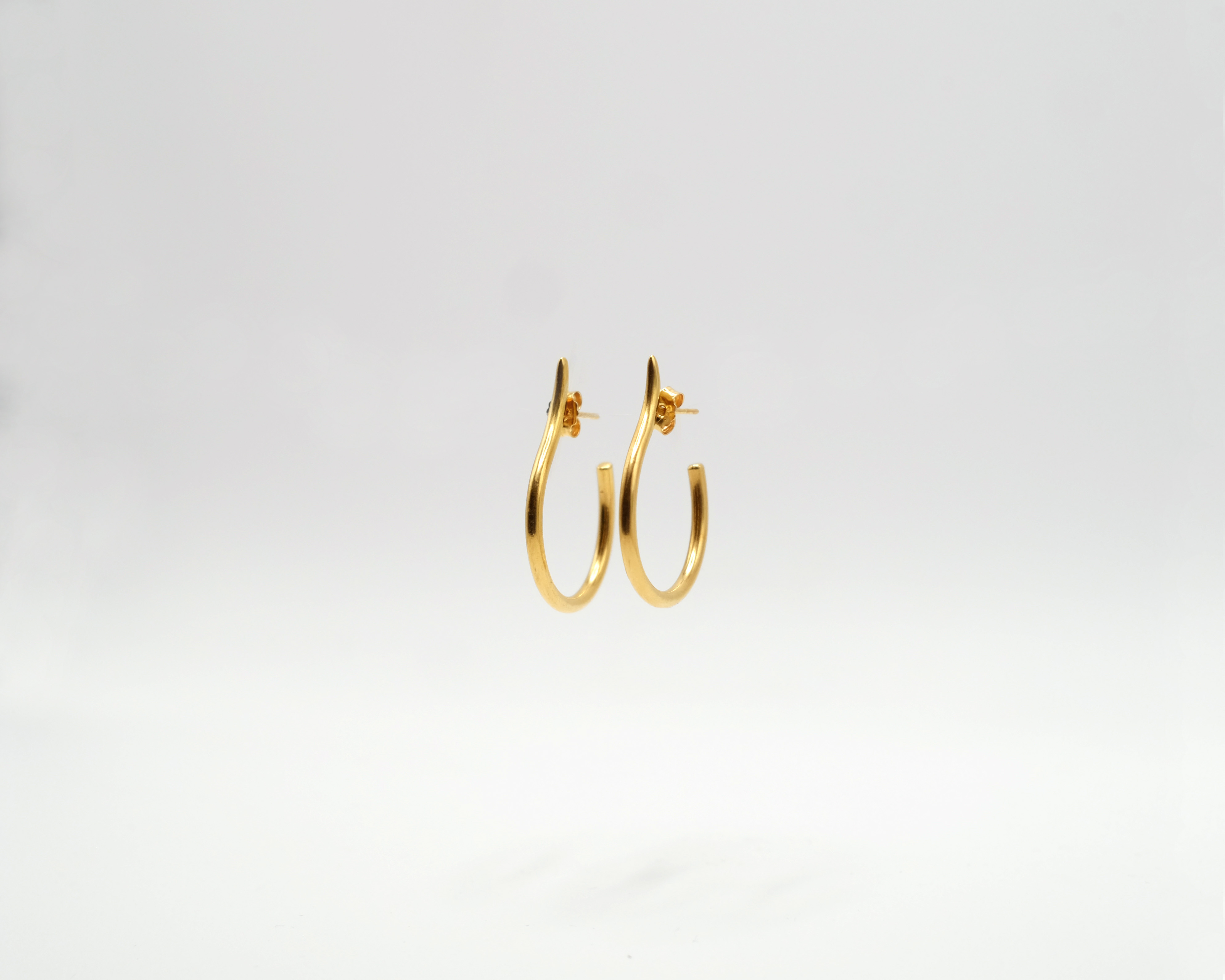 Mugura minimalist gold plated silver hoops.
