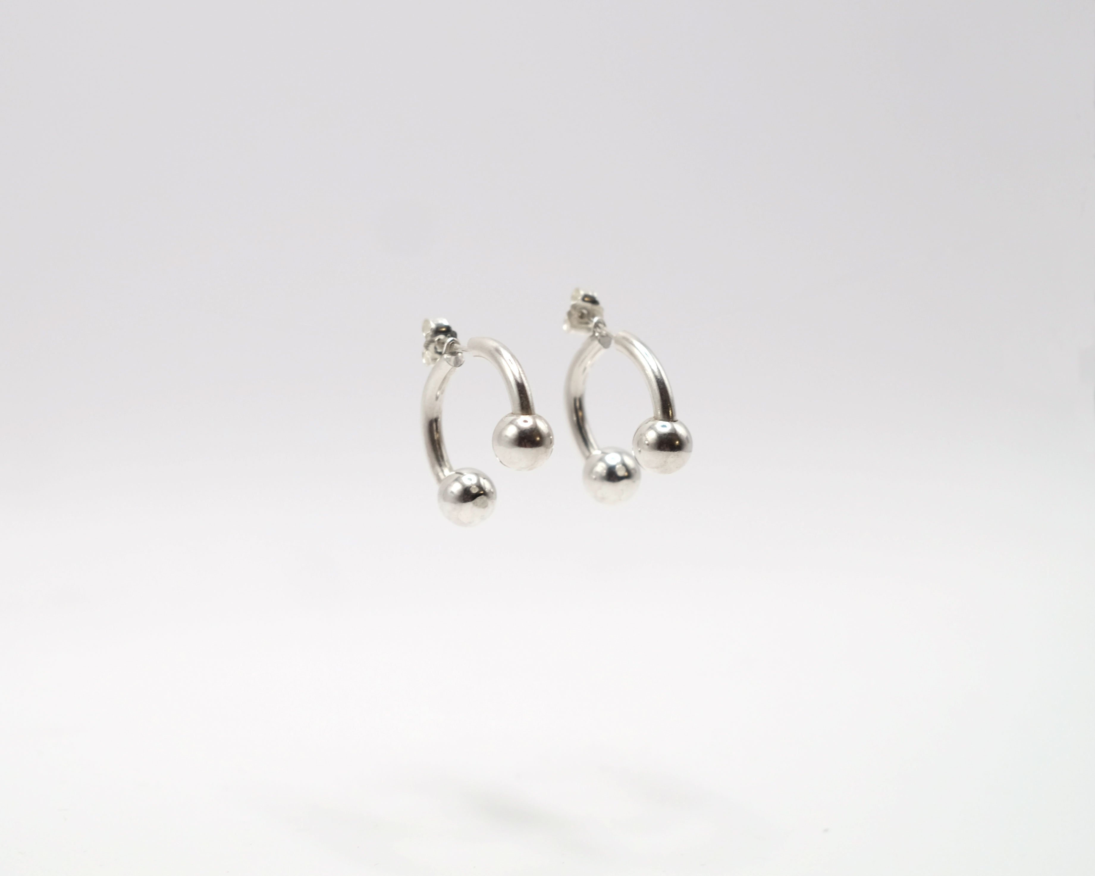 Piasu open hoops ending with a silver bead.