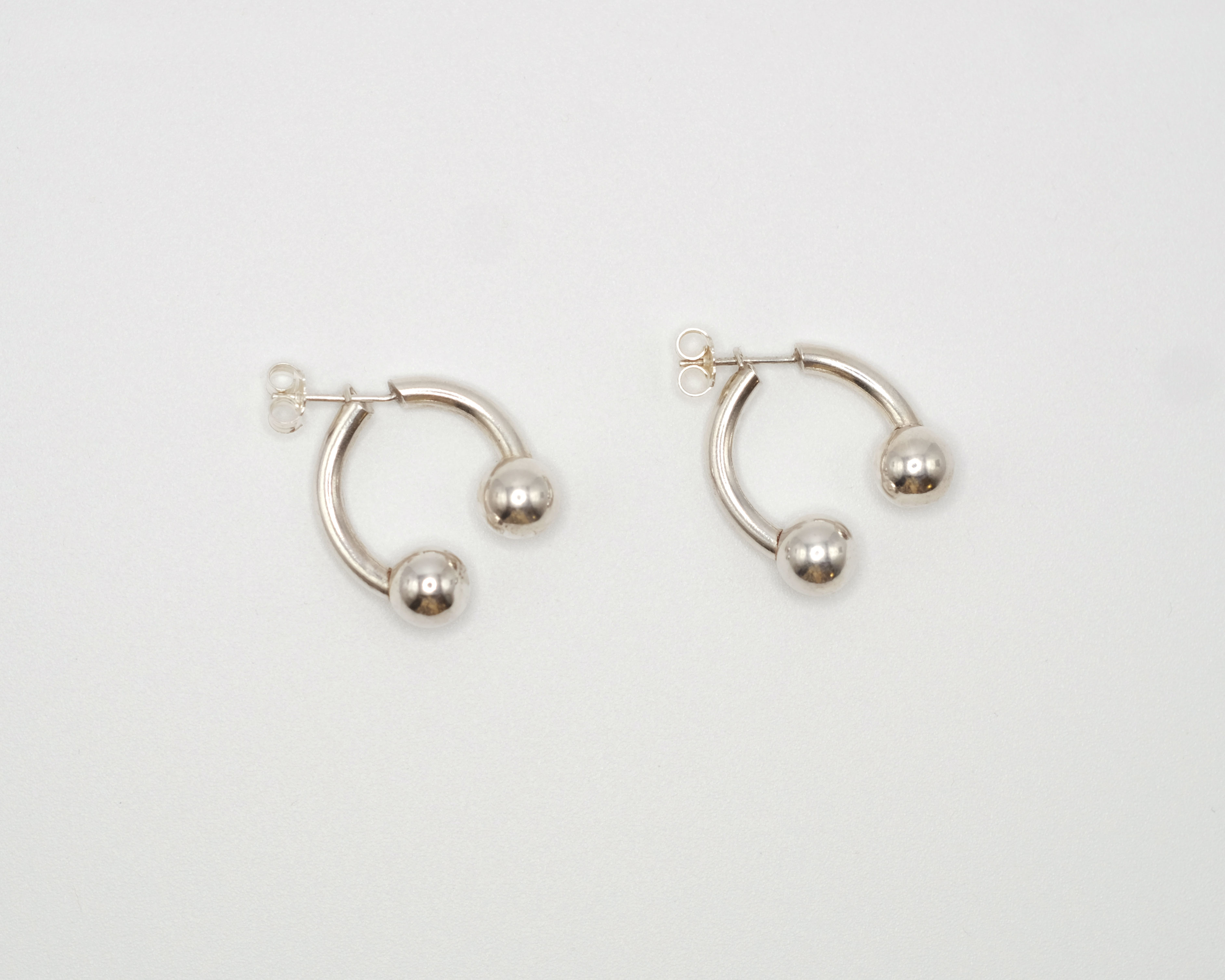 Piasu open hoops ending with a silver bead.