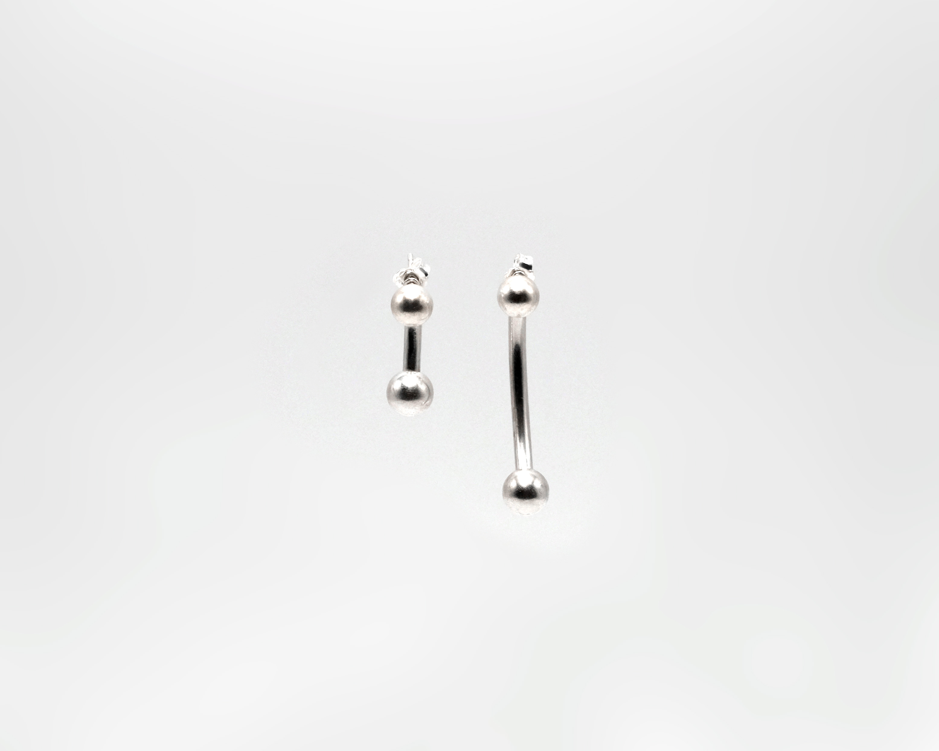 Piasu pending earrings. Maxi version of a stud piercing. In sterling silver.