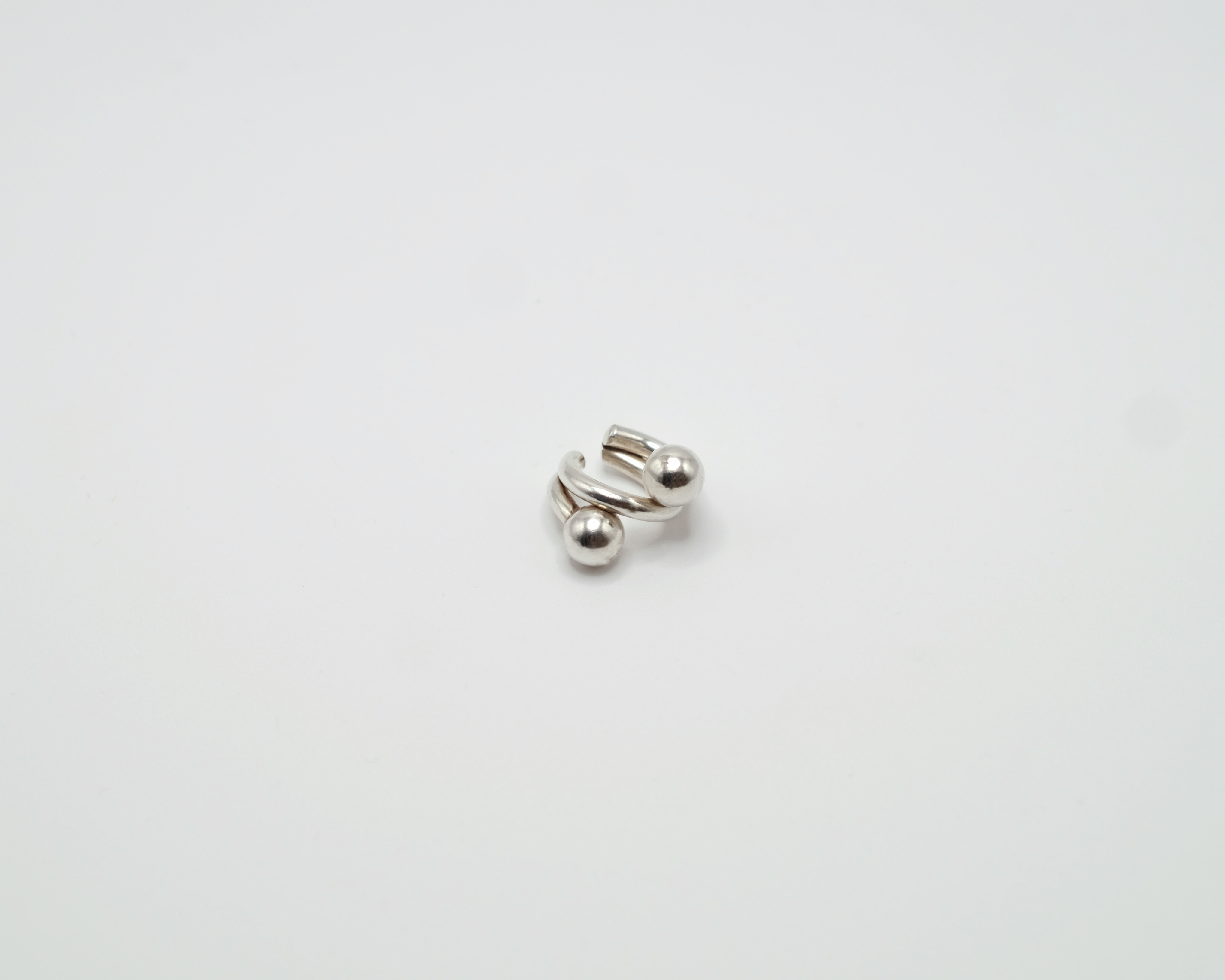 Piasu ear cuff in sterling silver. A statement piece composed of thick wires and silver beads.