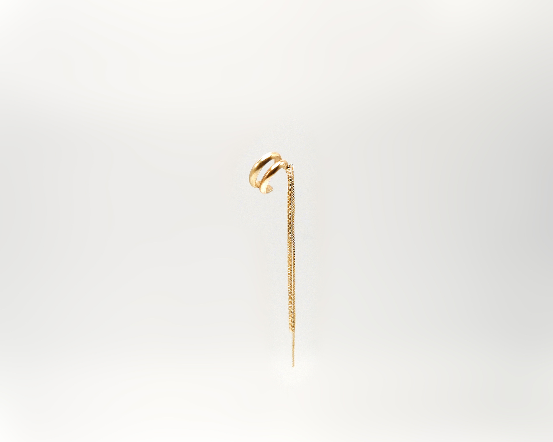 Tamanori ear cuff in gold plated silver with dangling chains.